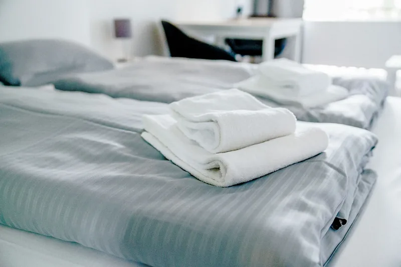 Vorbereitetes Doppelbett mit Handtüchern