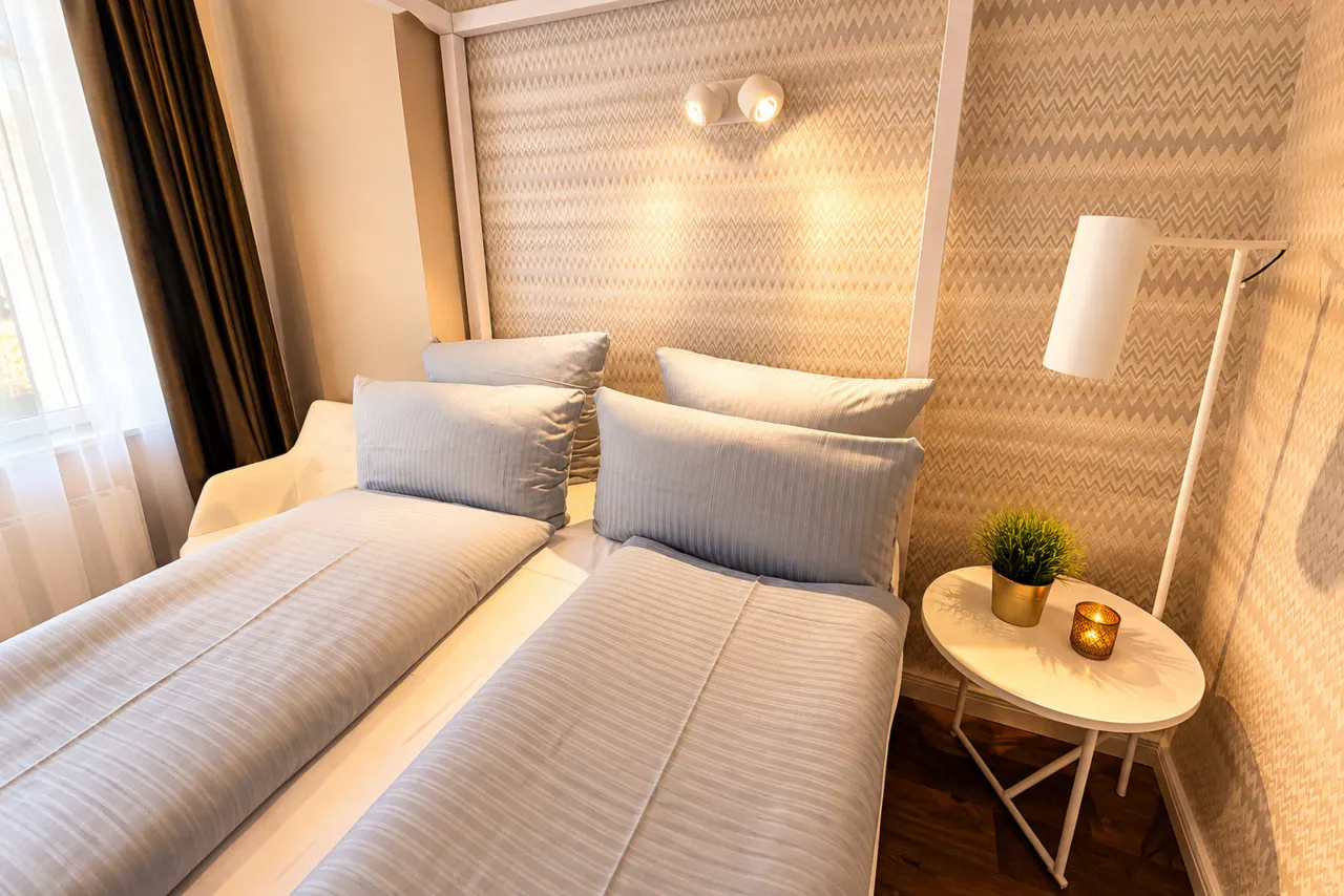 Zweites Schlafzimmer mit Doppelbett und Leseleuchte – Logierhof Goslar Wohnung 1 in Goslar
