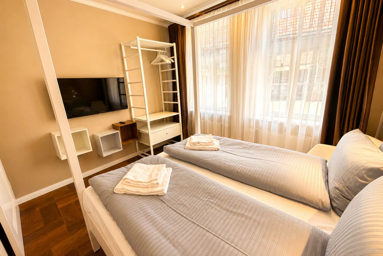 Schlafzimmer mit Kleiderständer und Fernseher – Logierhof Goslar Wohnung 1 in Goslar