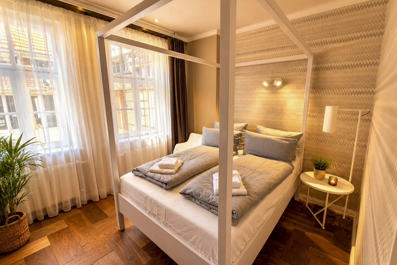 Schlafzimmer mit Himmelbett und Fensterfront – Logierhof Goslar Wohnung 1 in Goslar