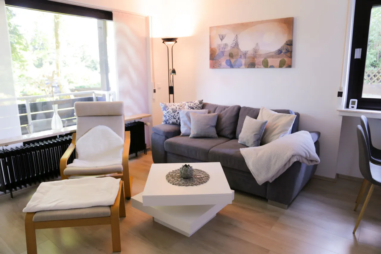 Wohnbereich mit Sofa, Sessel und Balkonzugang – Berg-Klee in Hahnenklee