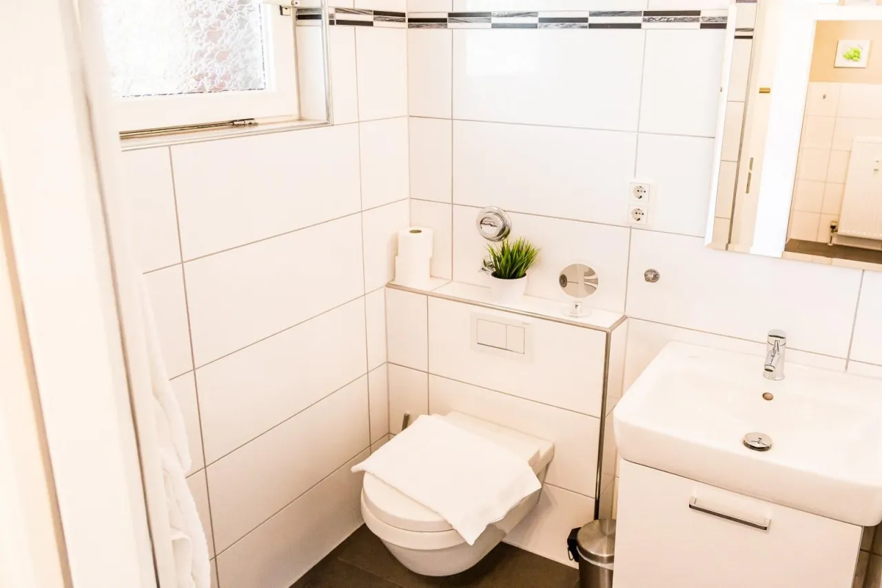 Badezimmer mit WC, Waschtisch und Fenster – Fewo Petra in Hahnenklee
