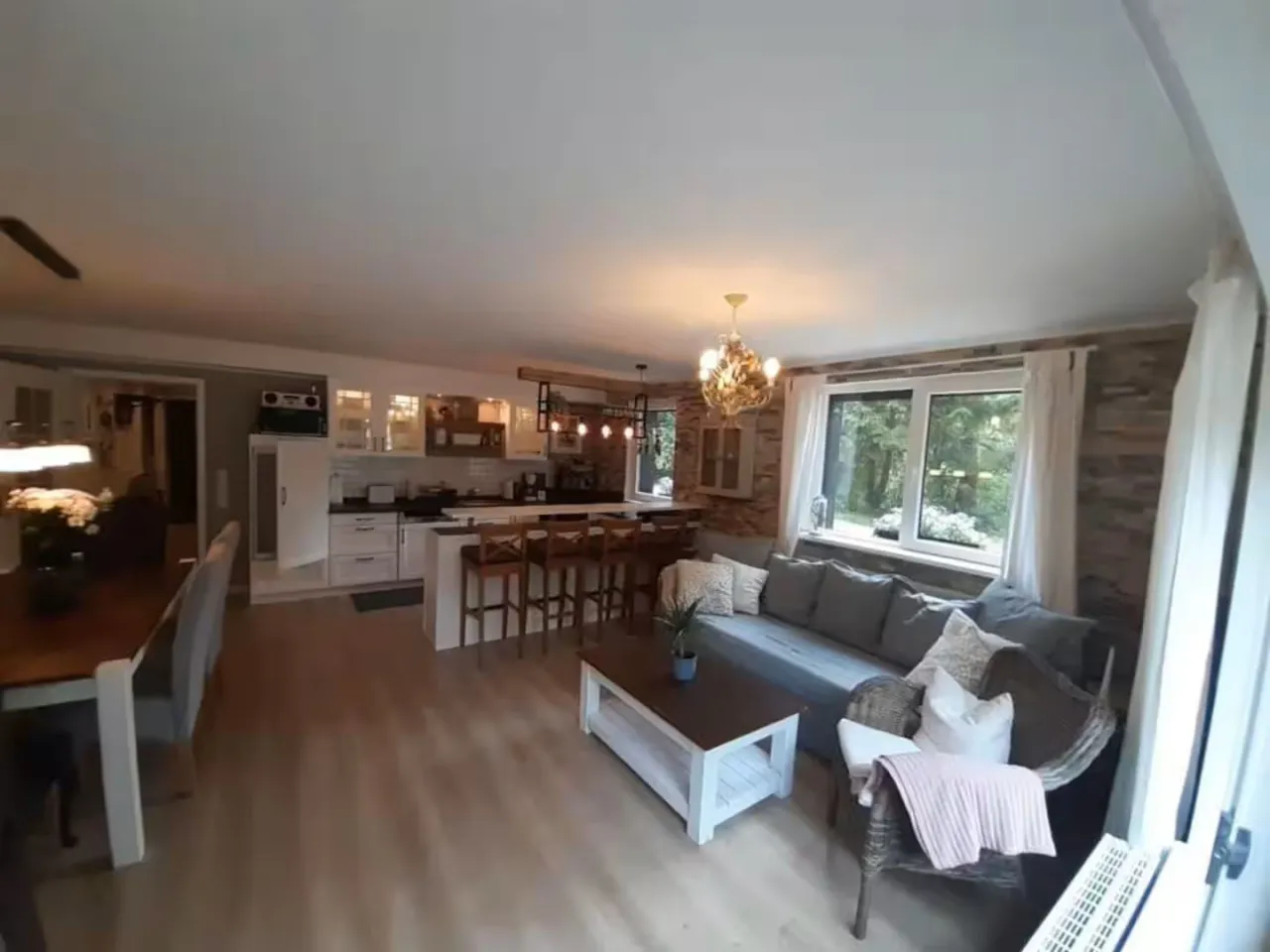 Wohnbereich mit Sofa, Kochinsel und Fensterfront – Harz-Forest-Inn in Hahnenklee