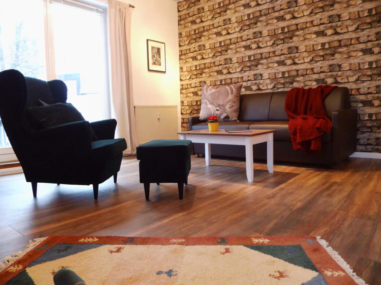 Wohnbereich mit Ohrensesseln, Sofa und Natursteinwand – Harzglück in Hahnenklee