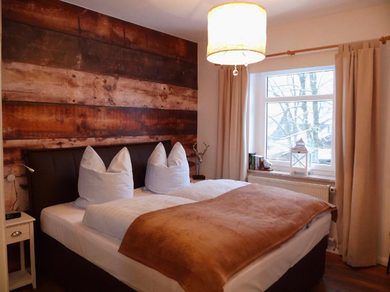 Schlafzimmer mit Doppelbett vor Holzwand – Harzglück in Hahnenklee