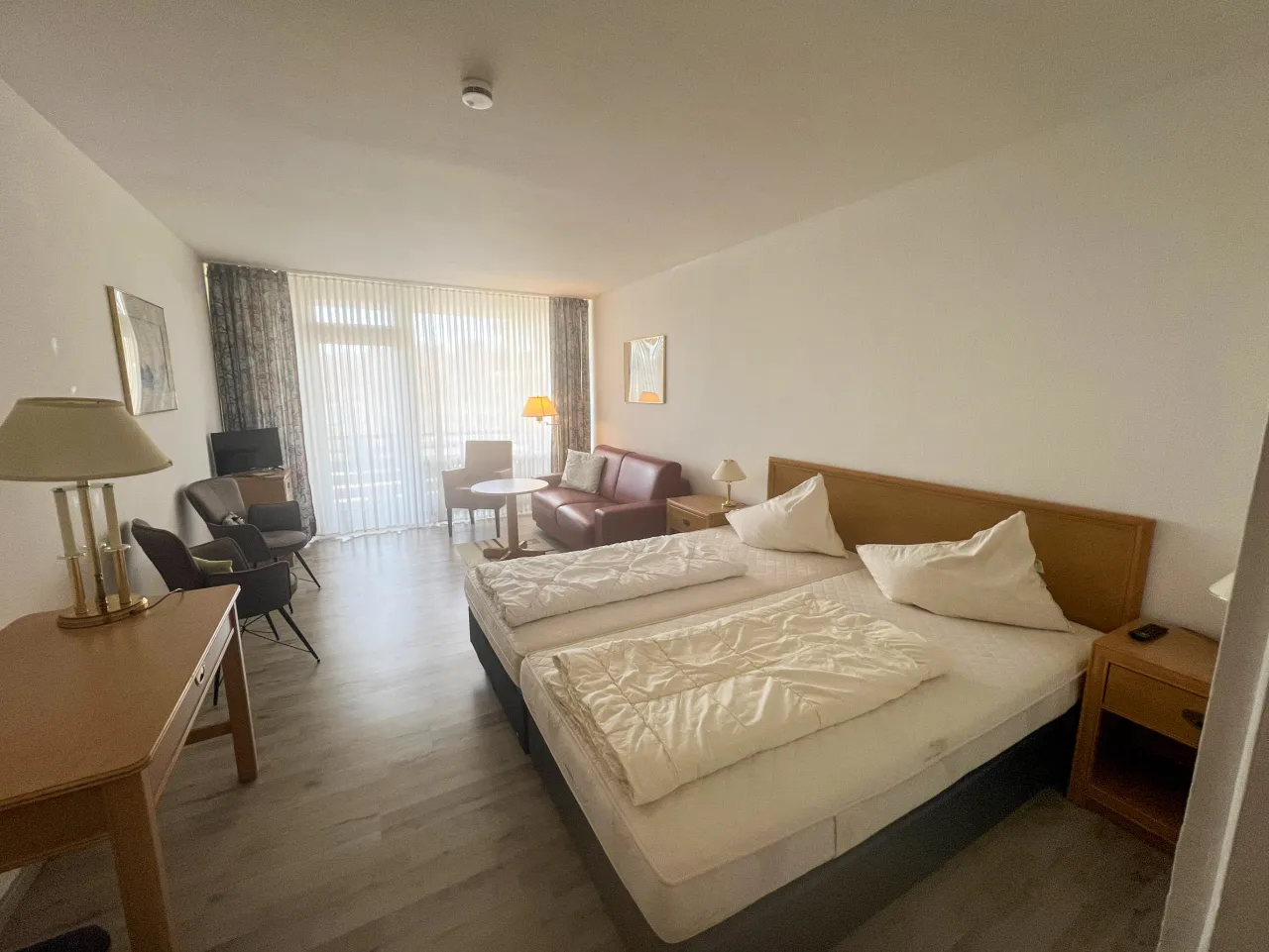 Zimmer mit Doppelbett, Sitzecke und Balkontür – Haus Vier Jahreszeiten am See Die Stille in Hahnenklee