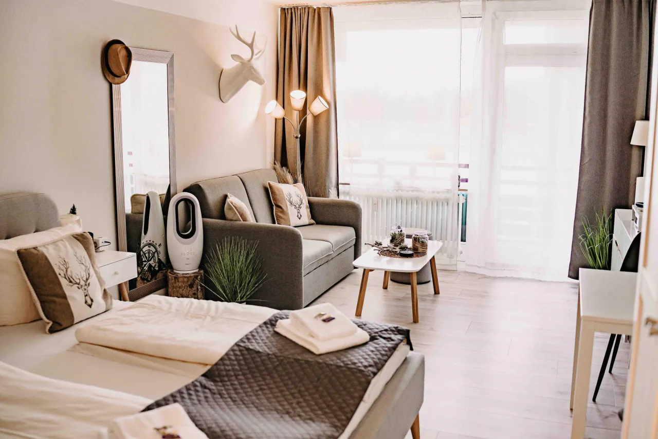 Studio mit Doppelbett, Sofa, Essplatz und Balkonfront – Haus Vier Jahreszeiten am See Harzflair in Hahnenklee