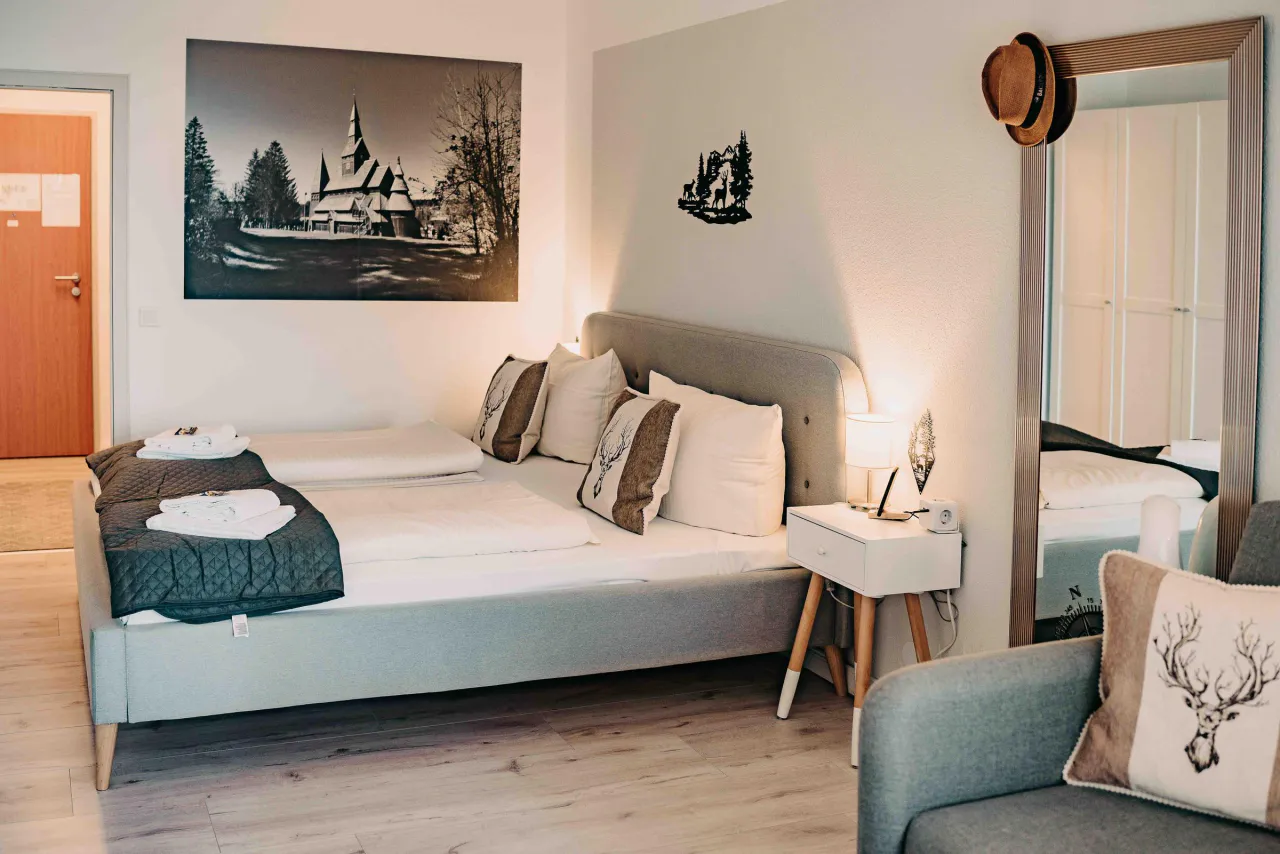 Schlafbereich mit Standspiegel und Sessel – Haus Vier Jahreszeiten am See Harzflair in Hahnenklee