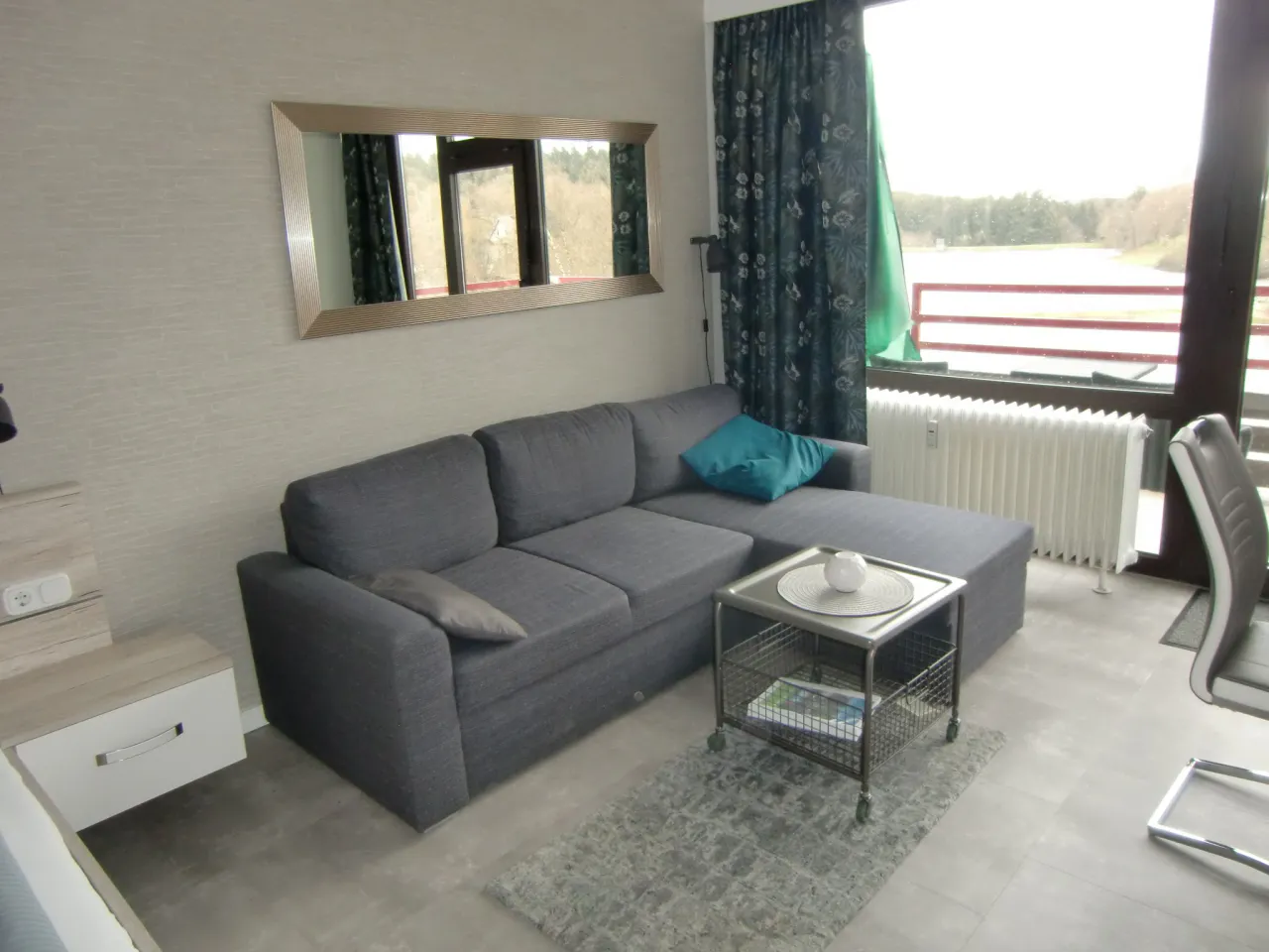 Sitzbereich mit Ecksofa und Wandspiegel – Haus Vier Jahreszeiten am See HS 576 in Hahnenklee