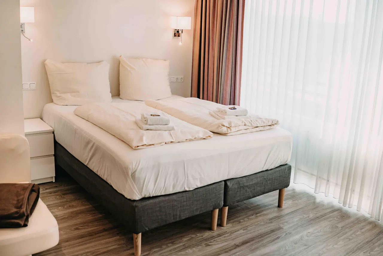 Doppelbett am Fenster mit Wandleuchte – Haus Vier Jahreszeiten am See Penthouse Klee in Hahnenklee
