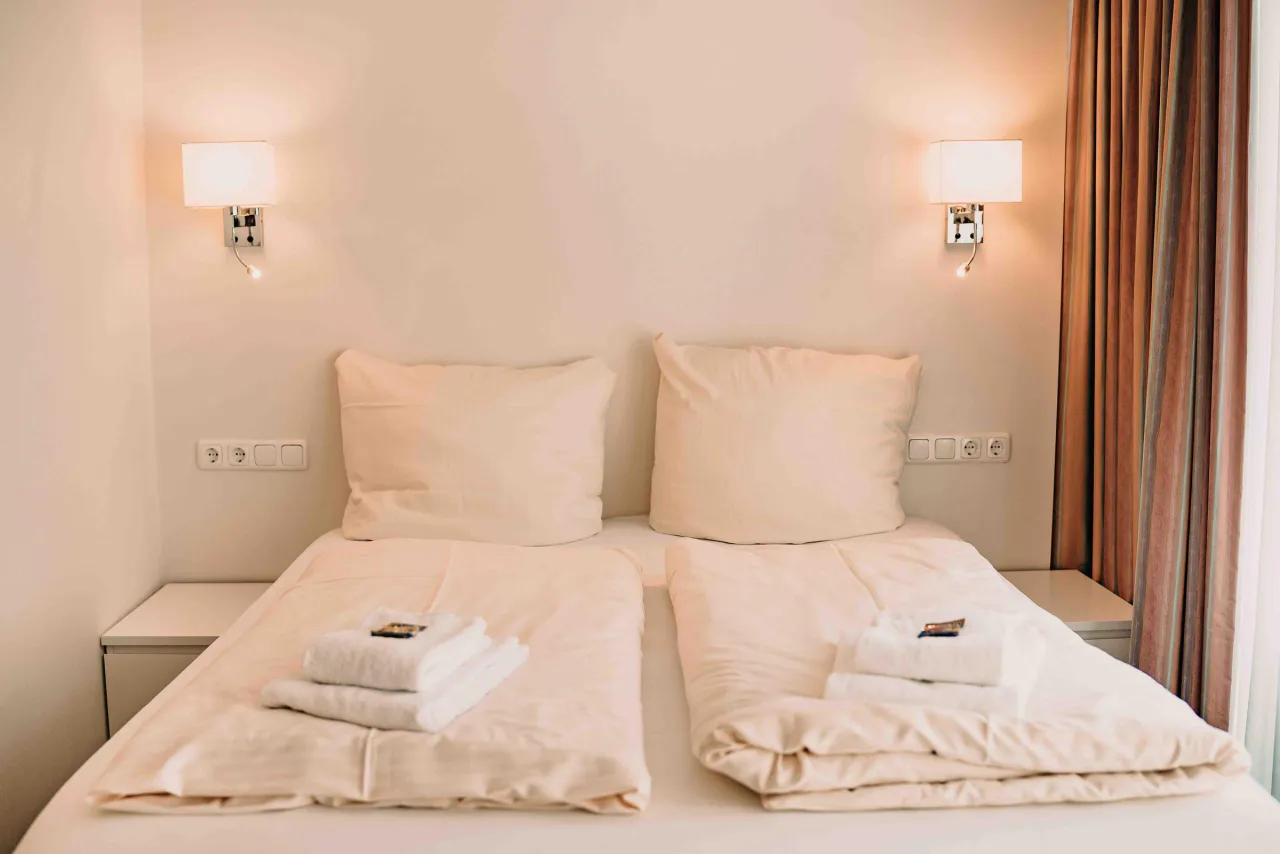 Doppelbett mit zwei Wandleuchten und Nachttischen – Haus Vier Jahreszeiten am See Penthouse Klee in Hahnenklee