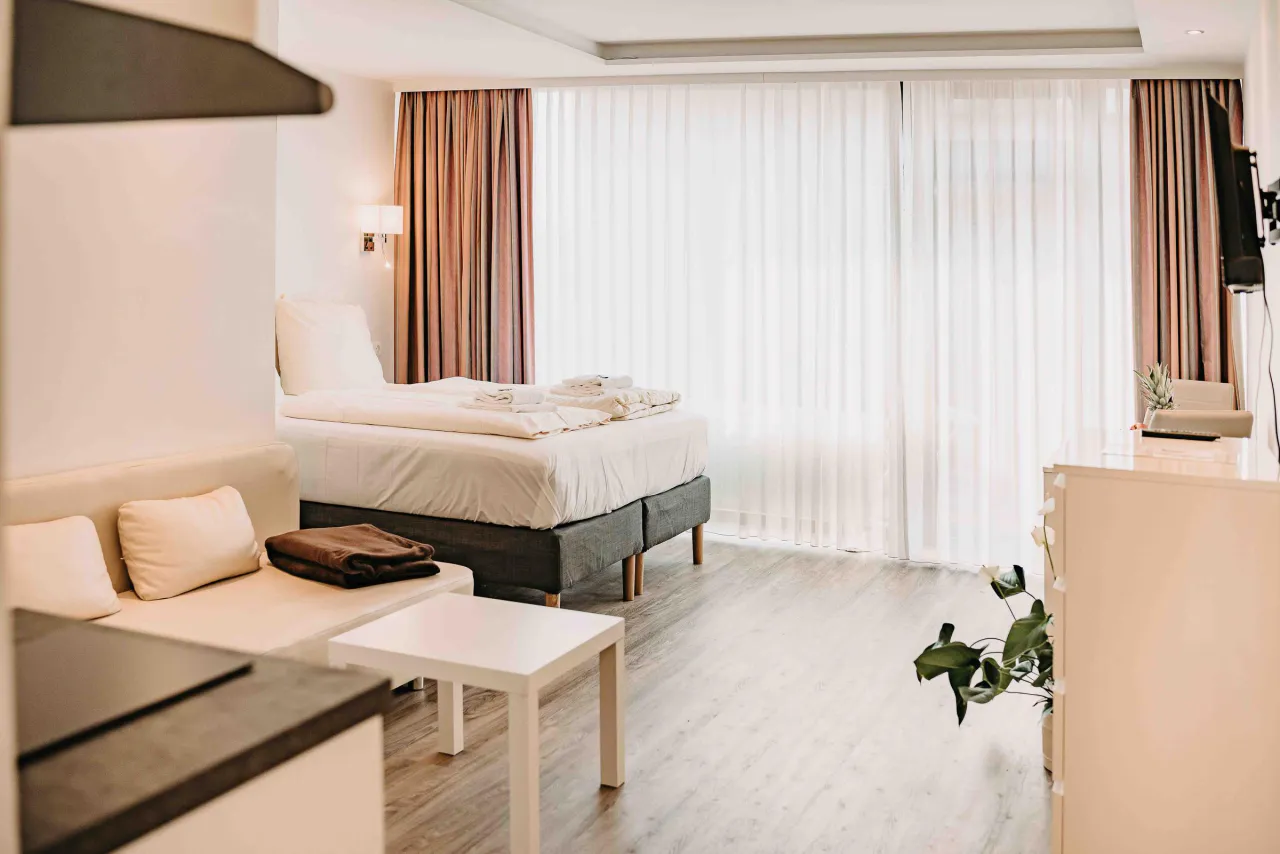 Studio mit Doppelbett, Sofa und Fensterfront – Haus Vier Jahreszeiten am See Penthouse Klee in Hahnenklee