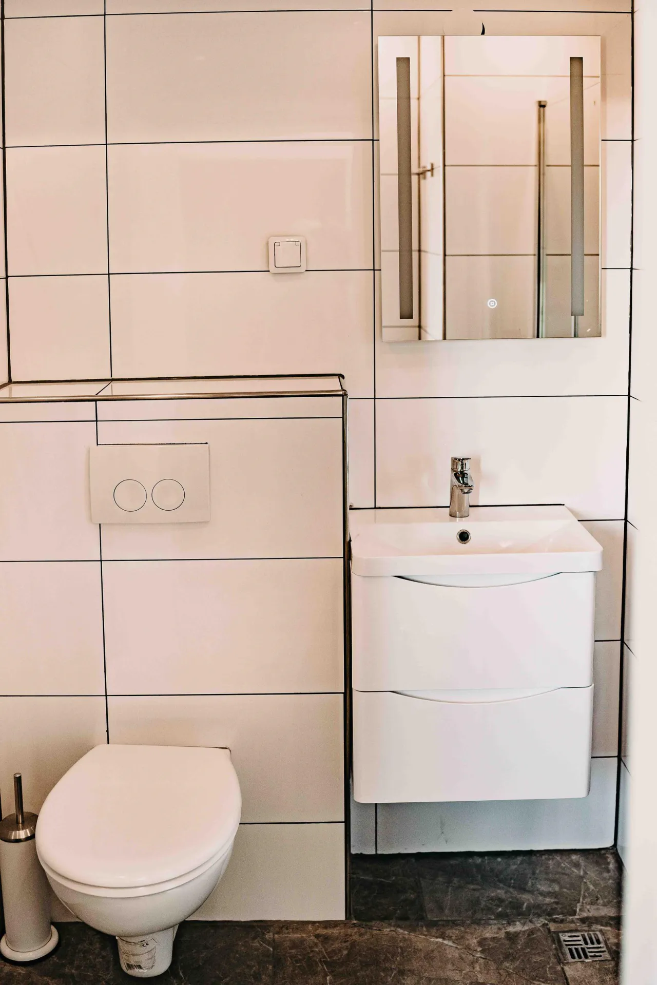 Badezimmer mit WC, Waschtisch und beleuchtetem Spiegelschrank – Haus Vier Jahreszeiten am See Penthouse Klee in Hahnenklee