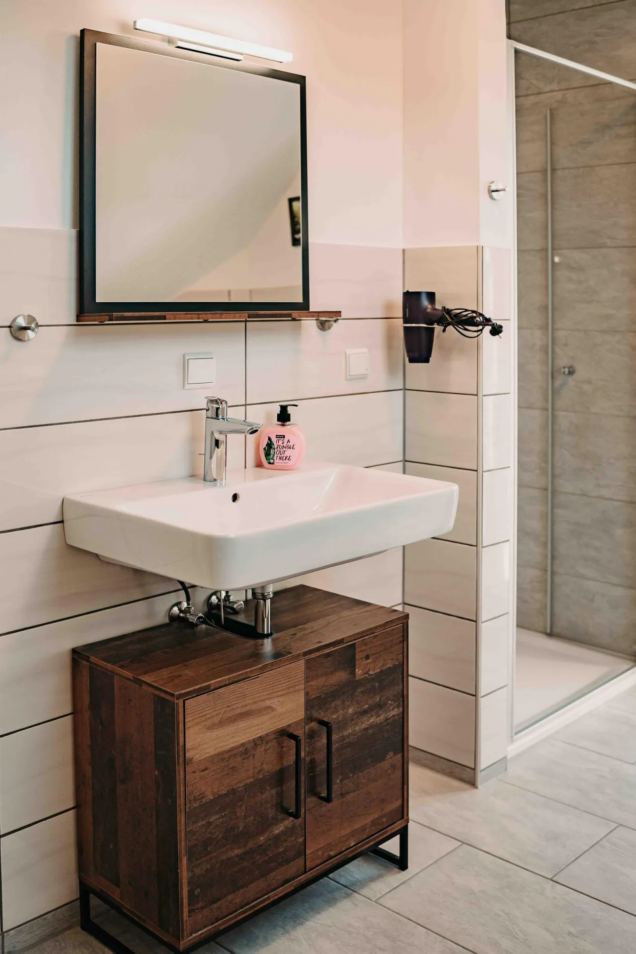 Badezimmer mit Waschtisch, Spiegel und Dusche – Sonneneck 2 in Hahnenklee