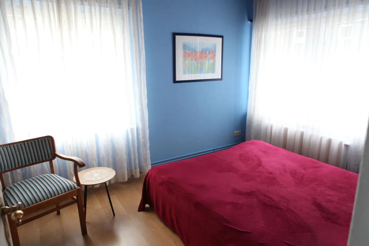Schlafzimmer mit Sessel und zwei Fenstern – Harz-Hütte am Bohlweg in Wildemann